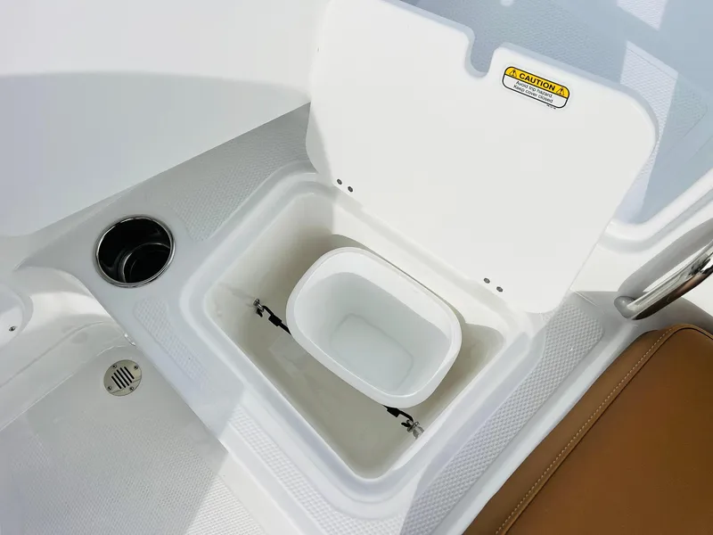 Slide: The Image of 2025 Tahoe 2150 boat storage compartment with cup holder and drain. - 34