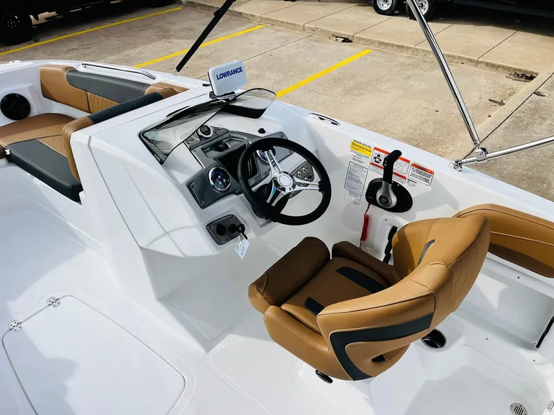 Slide: The Image of 2025 Tahoe 2150 boat interior with tan seats and modern steering console. - 35