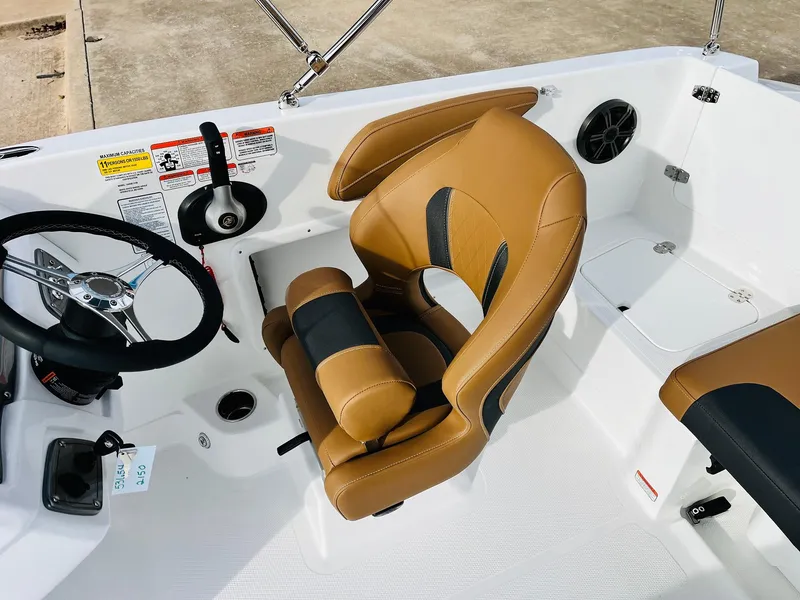 Slide: The Image of 2025 Tahoe 2150 boat interior with tan and black seating, steering wheel, and controls. - 37