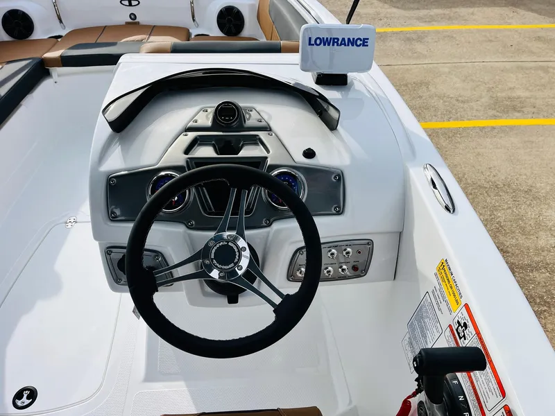 Slide: The Image of 2025 Tahoe 2150 boat dashboard with steering wheel and Lowrance navigation system. - 38