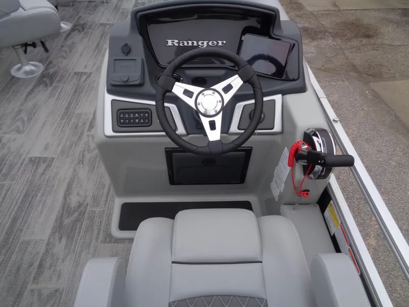 Slide: The Image of 2025 Ranger Reata 220FC boat dashboard with steering wheel and controls. - 13