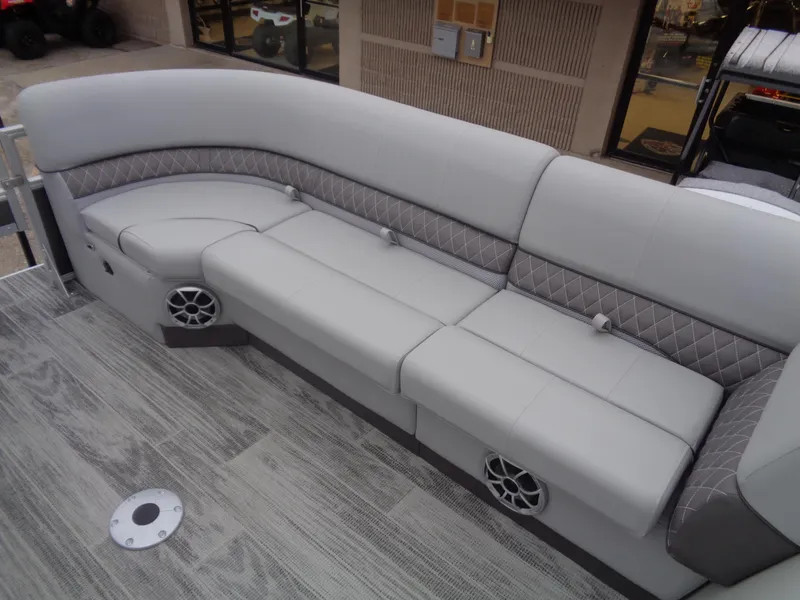 Slide: The Image of 2025 Ranger Reata 220FC boat interior with gray cushioned seating and speakers. - 9