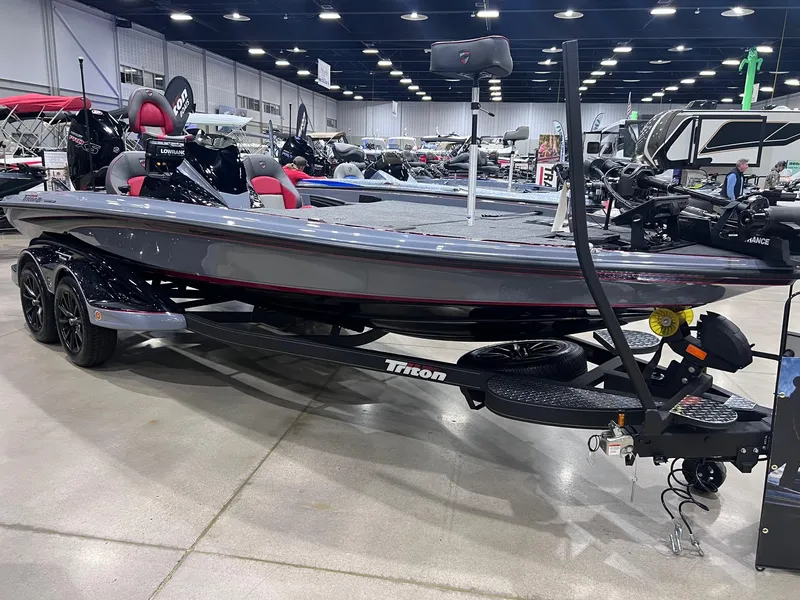 Slide: The Image of 2025 Triton 21XP Patriot boat displayed indoors on a trailer. - 0