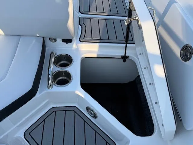 Slide: The Image of 2025 Sea Ray SPX 230 boat interior with storage compartment and cup holders. - 10