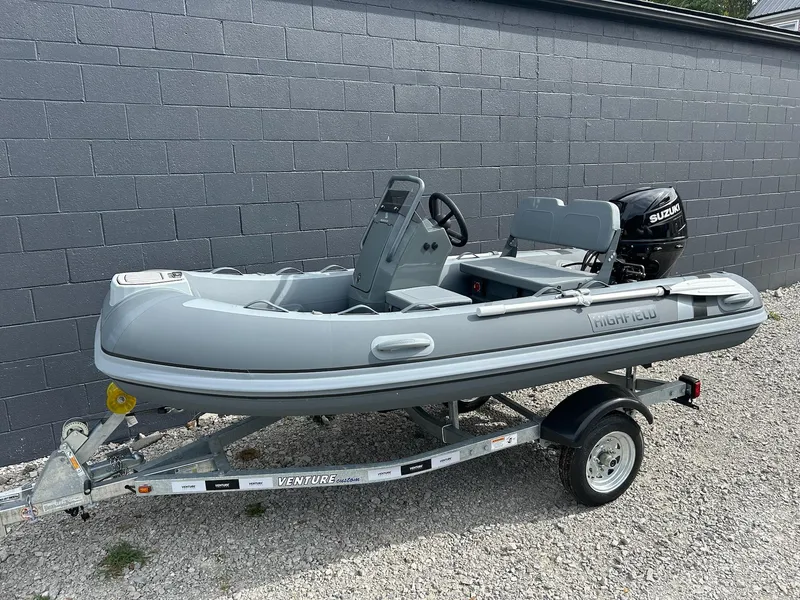 Slide: The Image of 2023 Highfield Classic 340 GT inflatable boat on trailer, gray exterior, Suzuki outboard motor. - 10