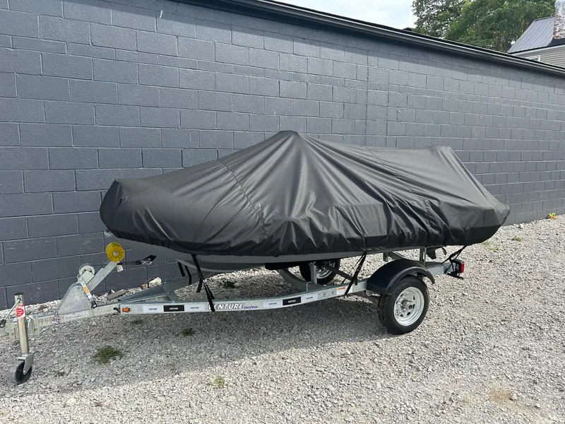 Slide: The Image of 2023 Highfield Classic 340 GT boat covered on trailer, parked on gravel. - 11