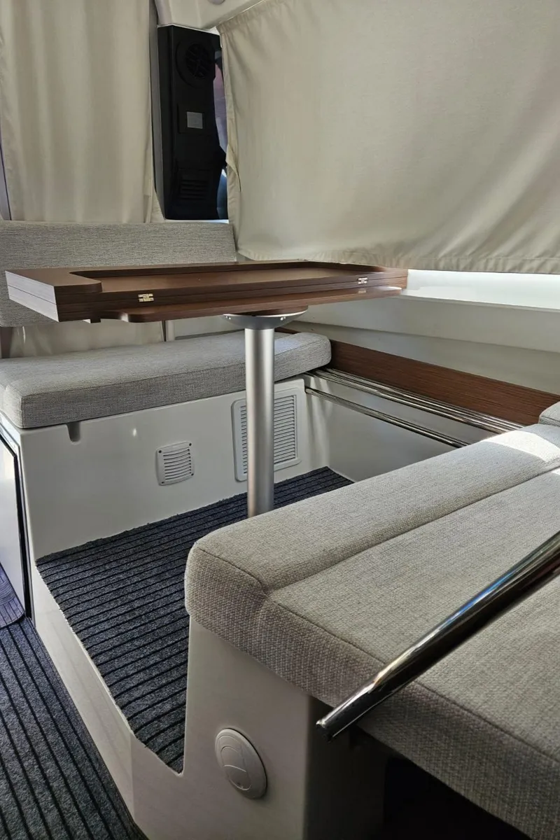 Slide: The Image of Interior of 2023 Jeanneau NC795 boat with modern seating and table. - 18