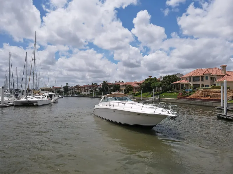 Slide: The Image of 1996 Sea Ray 500 Sundancer yacht cruising in a scenic marina with luxury homes. - 11