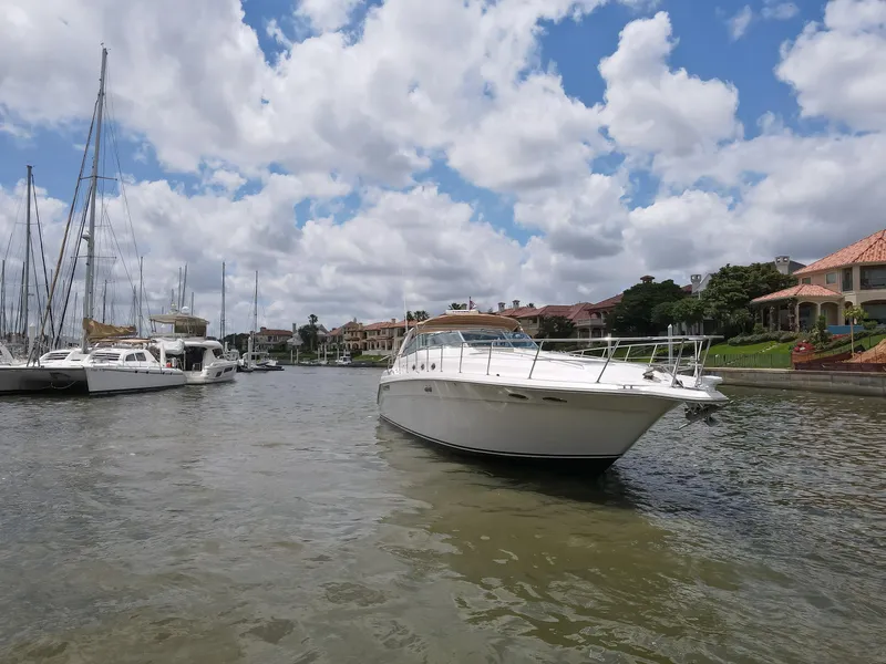 Slide: The Image of 1996 Sea Ray 500 Sundancer yacht docked in a scenic marina under a cloudy sky. - 15