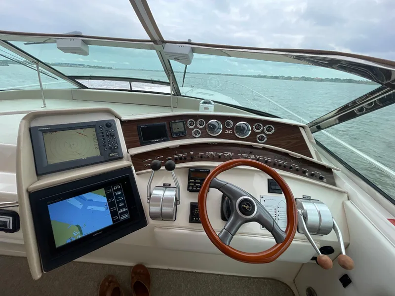 Slide: The Image of 1996 Sea Ray 500 Sundancer helm with navigation screens and wooden steering wheel. - 25