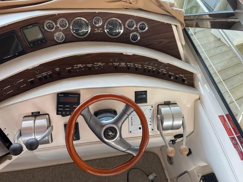 Slide: The Image of 1996 Sea Ray 500 Sundancer helm with wood accents and modern controls. - 26