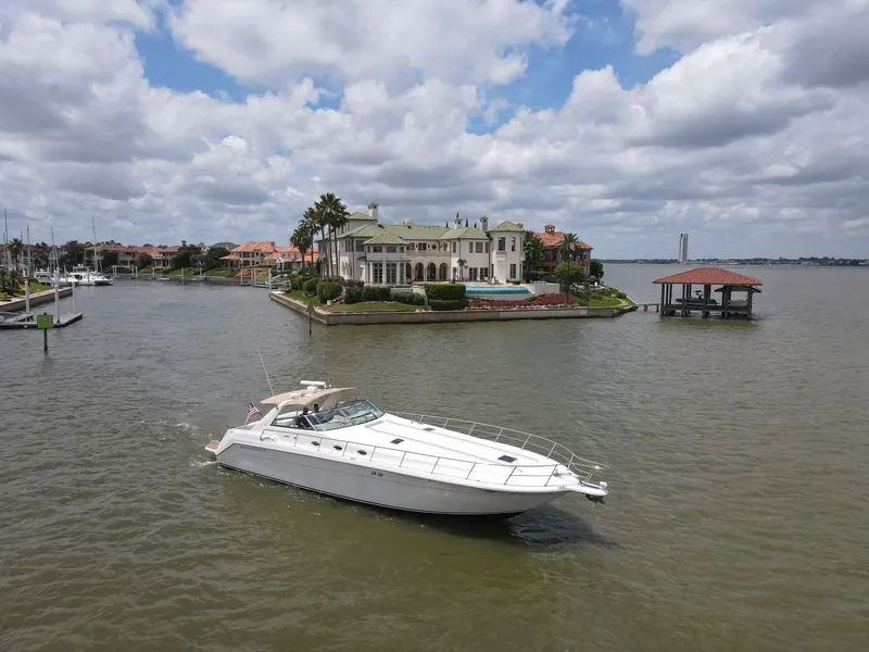 Slide: The Image of 1996 Sea Ray 500 Sundancer yacht cruising near luxurious waterfront mansion. - 6