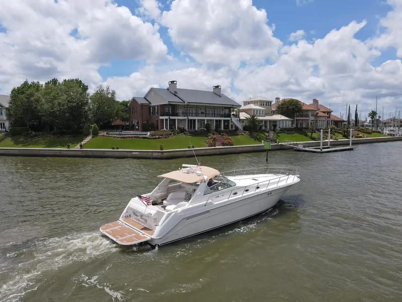 Slide: The Image of 1996 Sea Ray 500 Sundancer cruising on a scenic river near luxury waterfront homes. - 7