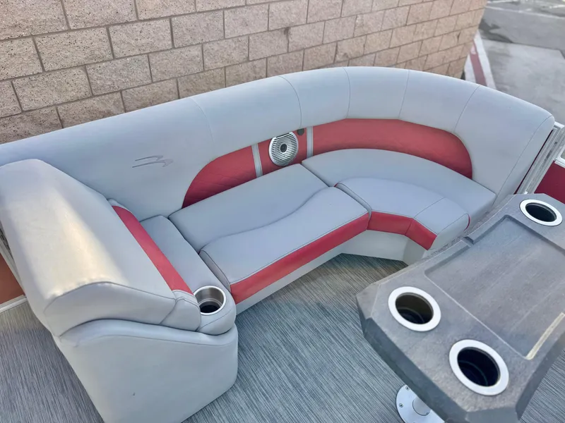 Slide: The Image of 2021 Bennington 23 LS RSD boat seating with red and gray upholstery and cup holders. - 11