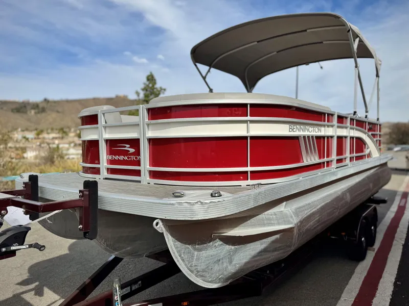 Slide: The Image of 2021 Bennington 23 LS RSD pontoon boat with red exterior on a trailer. - 3