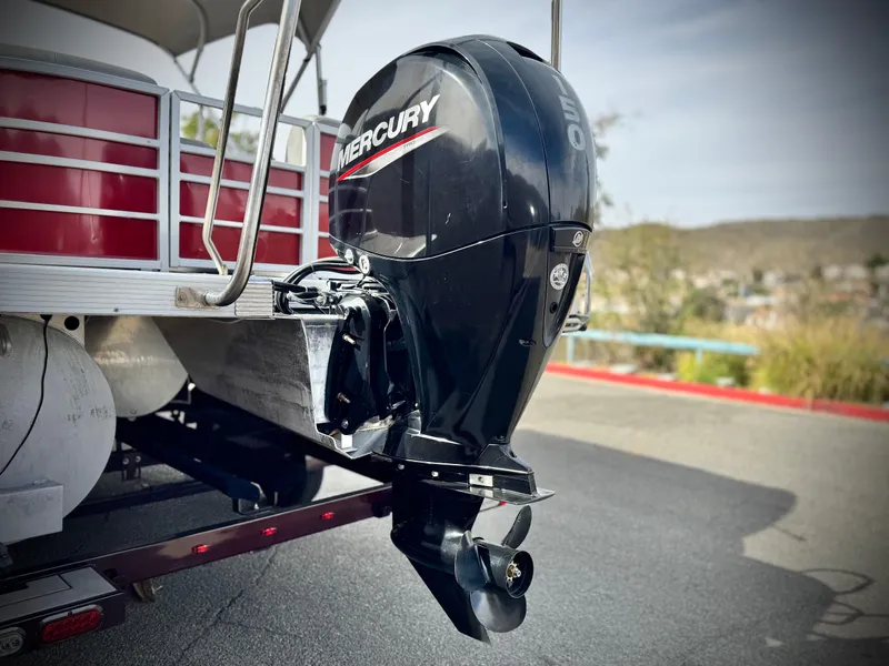 Slide: The Image of 2021 Bennington 23 LS RSD with Mercury outboard motor, parked on a trailer. - 7