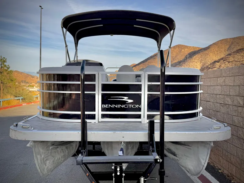 Slide: The Image of 2021 Bennington 23 LPD pontoon boat on trailer, scenic mountain backdrop. - 2