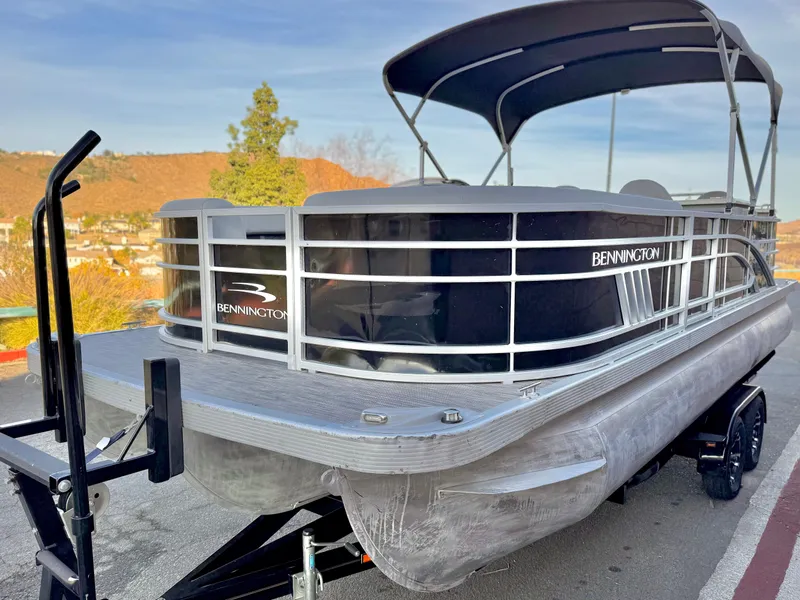 Slide: The Image of 2021 Bennington 23 LPD pontoon boat on trailer, featuring sleek design and canopy. - 4