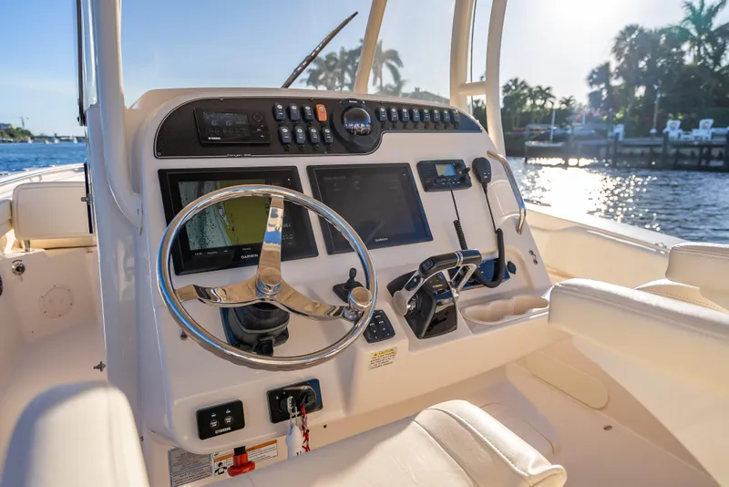 Slide: The Image of 2017 Grady-White Canyon 306 boat dashboard with steering wheel and navigation controls. - 46