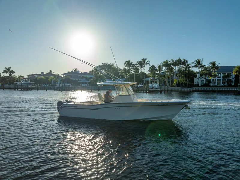 Slide: The Image of 2017 Grady-White Canyon 306 boat cruising on a sunny waterfront with palm trees. - 6