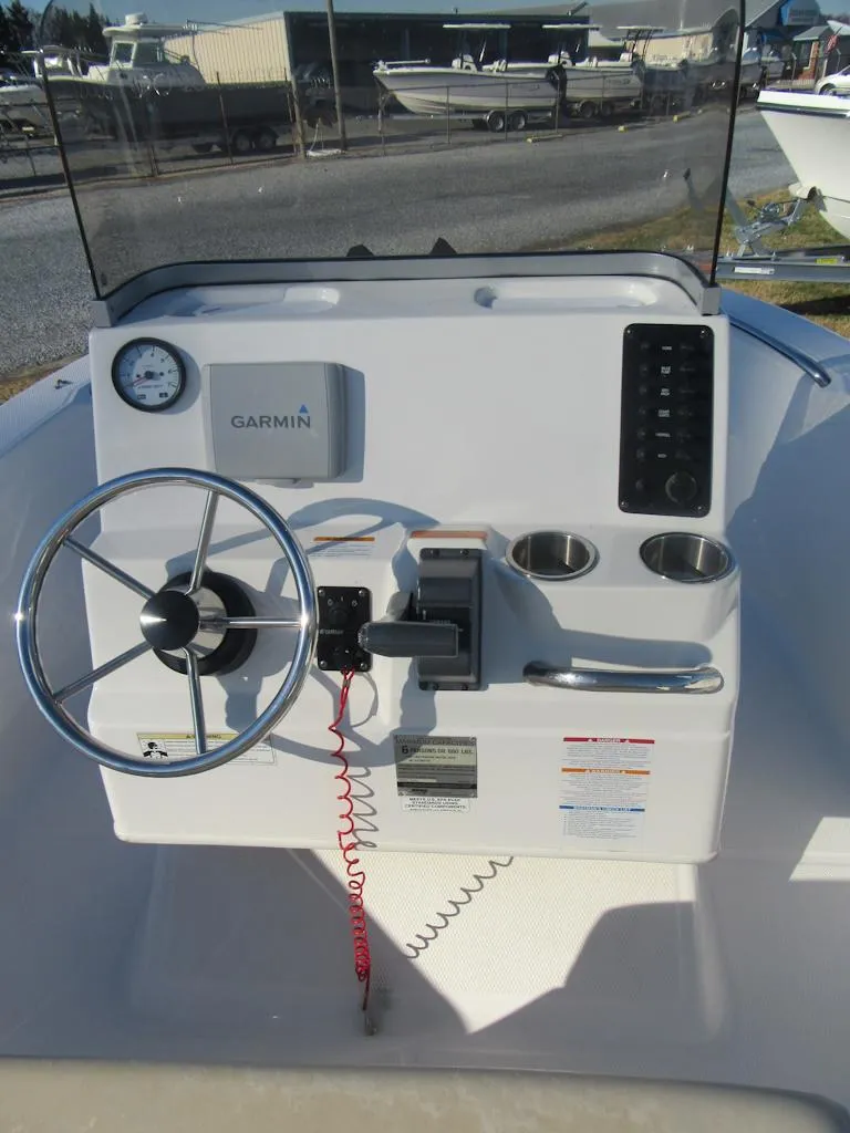 Slide: The Image of 2016 Robalo R160 Center Console boat dashboard with steering wheel and Garmin display. - 12