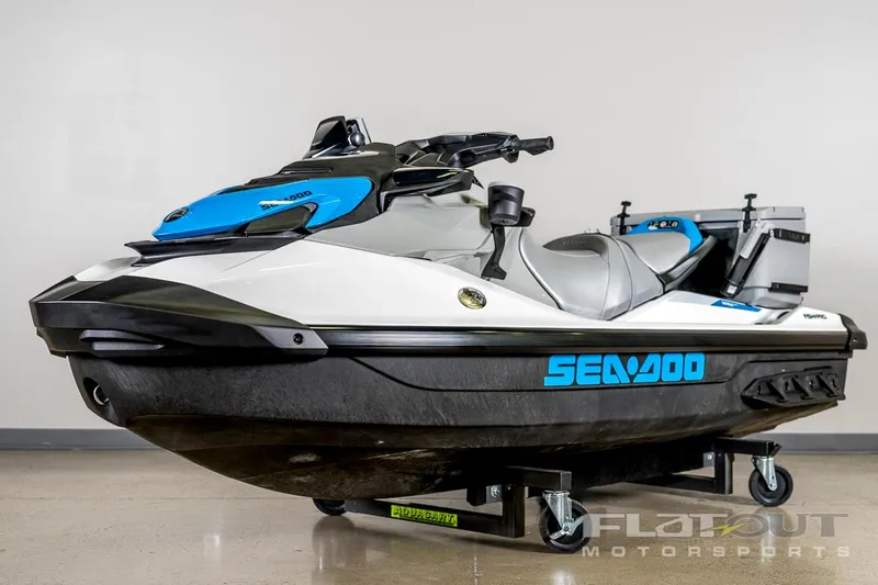 Slide: The Image of 2024 Sea-Doo Fish Pro 130 Scout jet ski, white and blue, displayed indoors. - 2