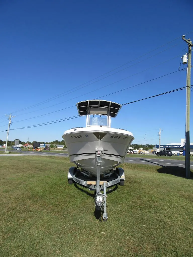 Slide: The Image of 2018 Robalo R222 Center Console boat on trailer, parked on grass under clear blue sky. - 21