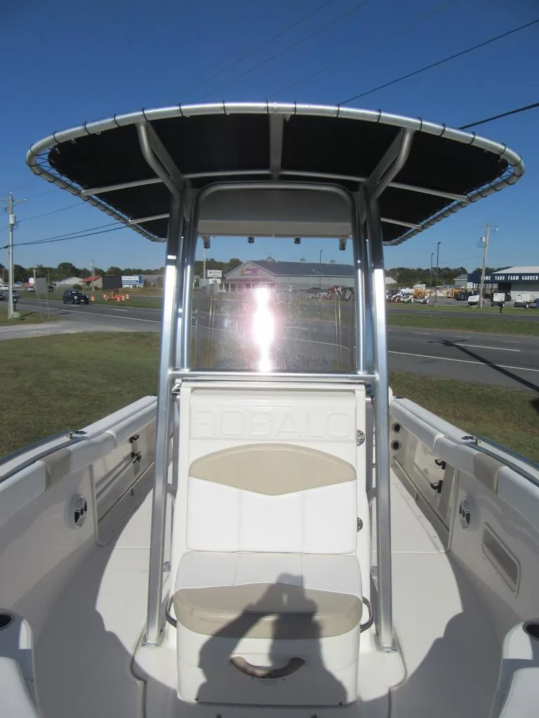 Slide: The Image of 2018 Robalo R222 Center Console boat with T-top and seating, parked outdoors. - 6