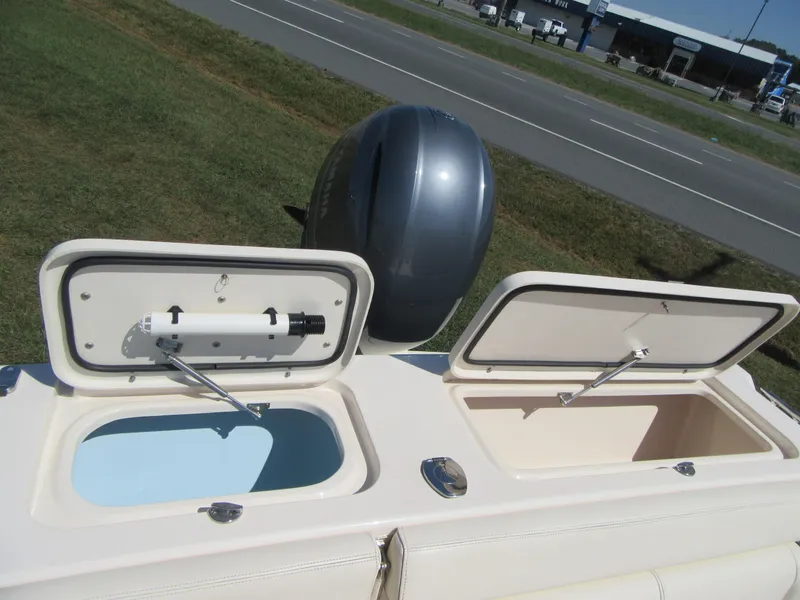 Slide: The Image of 2017 Grady-White 225 Freedom boat with open storage compartments and outboard motor. - 10