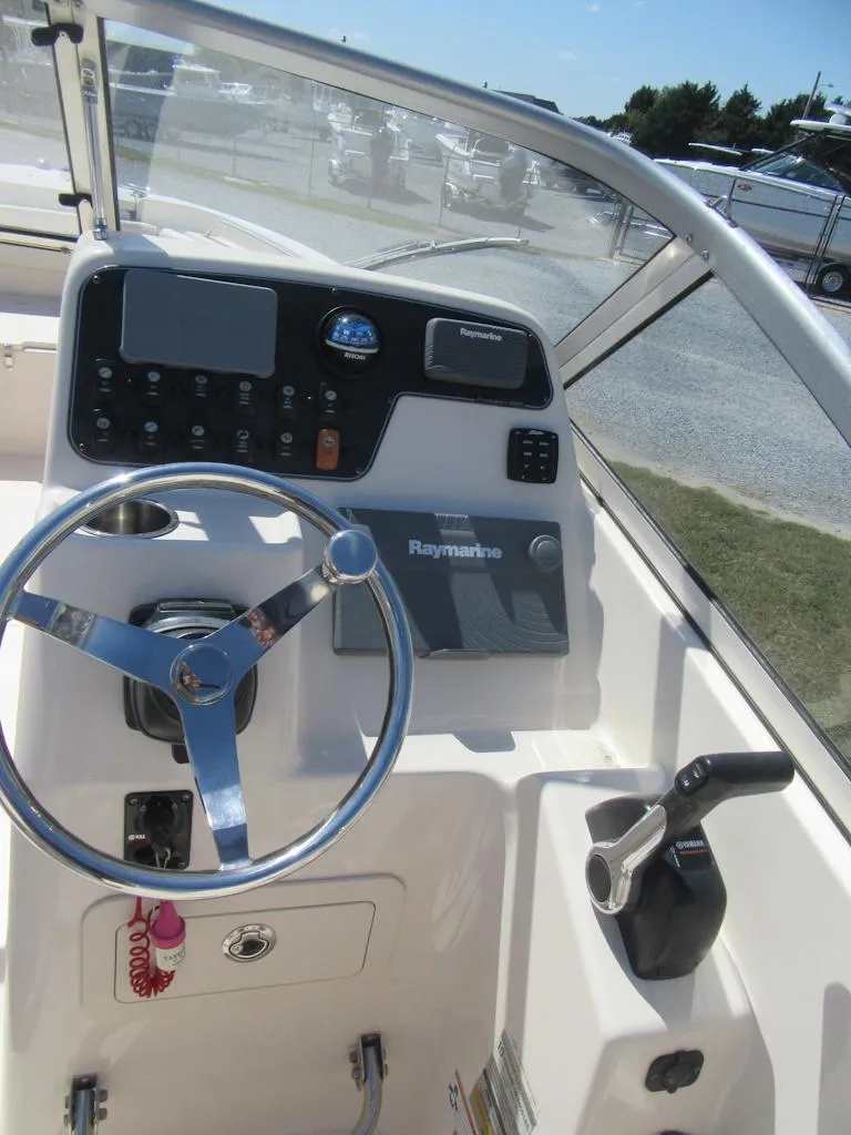 Slide: The Image of 2017 Grady-White 225 Freedom boat dashboard with steering wheel and controls. - 18