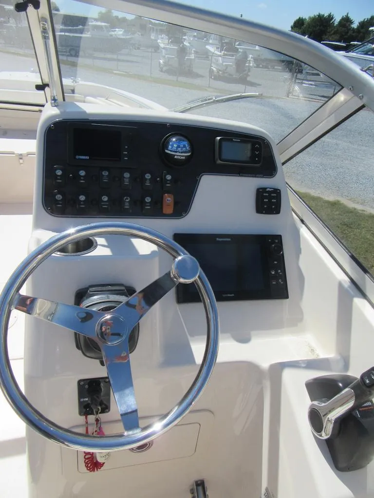 Slide: The Image of 2017 Grady-White 225 Freedom boat dashboard with steering wheel and controls. - 19