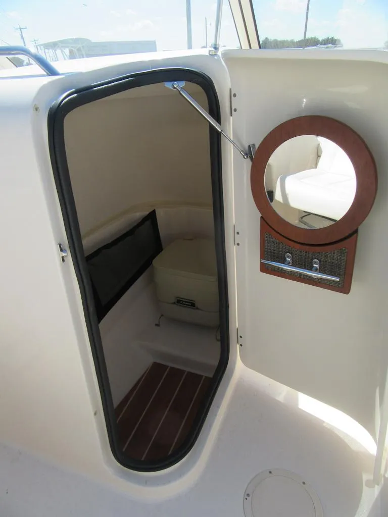 Slide: The Image of 2017 Grady-White 225 Freedom boat cabin interior with circular window and seating. - 21