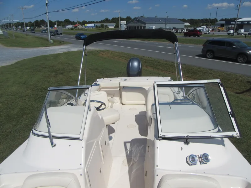 Slide: The Image of 2017 Grady-White 225 Freedom boat with open cockpit and windshield, parked near a road. - 24