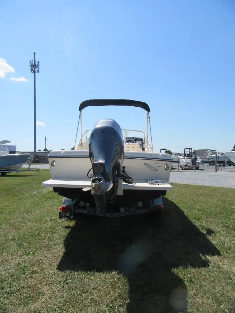 Slide: The Image of 2017 Grady-White 225 Freedom boat on trailer, parked on grass under clear blue sky. - 4