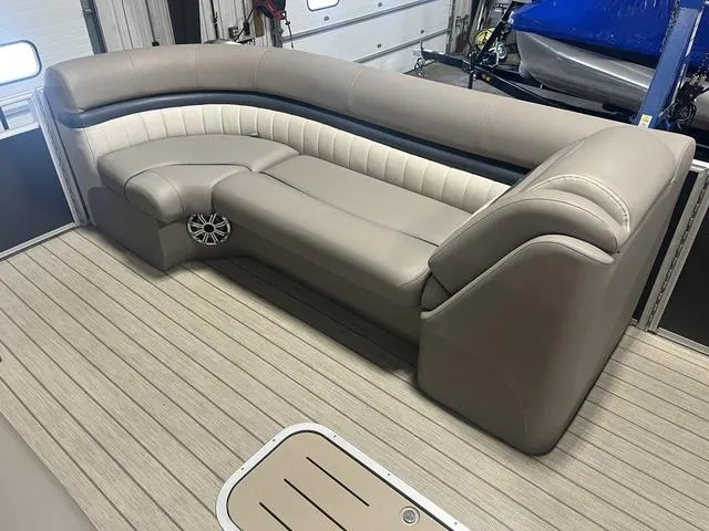 Slide: The Image of 2018 Bennington 25GSB boat interior with beige seating and wood-style flooring. - 13