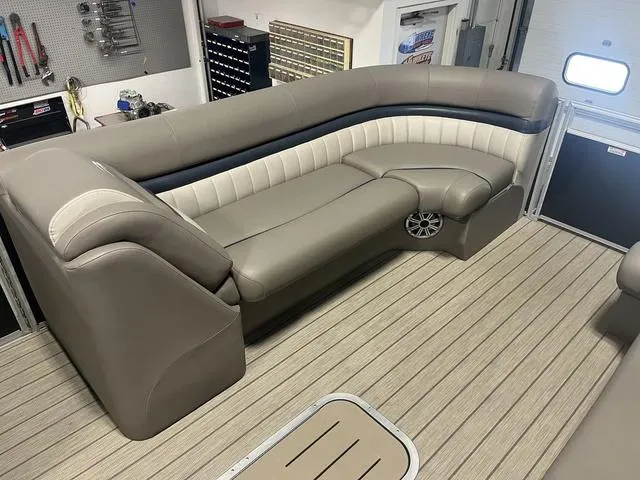 Slide: The Image of 2018 Bennington 25GSB boat interior with beige seating and wood-style flooring. - 14