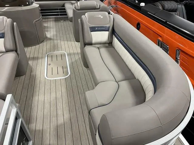 Slide: The Image of 2018 Bennington 25GSB boat interior with beige seating and wood-style flooring. - 16