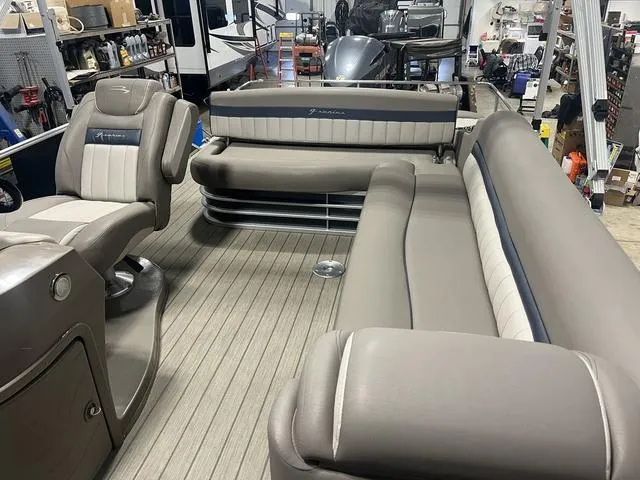 Slide: The Image of 2018 Bennington 25GSB pontoon boat interior with plush seating in a workshop setting. - 8