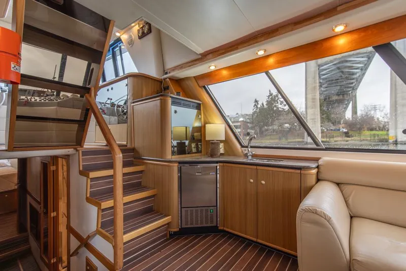 Slide: The Image of Interior of 2000 Bayliner 4788 Pilot House Motoryacht with modern wood finishes and large windows. - 15
