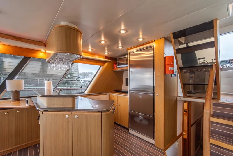 Slide: The Image of Interior of 2000 Bayliner 4788 Pilot House Motoryacht with modern kitchen and wood finishes. - 20