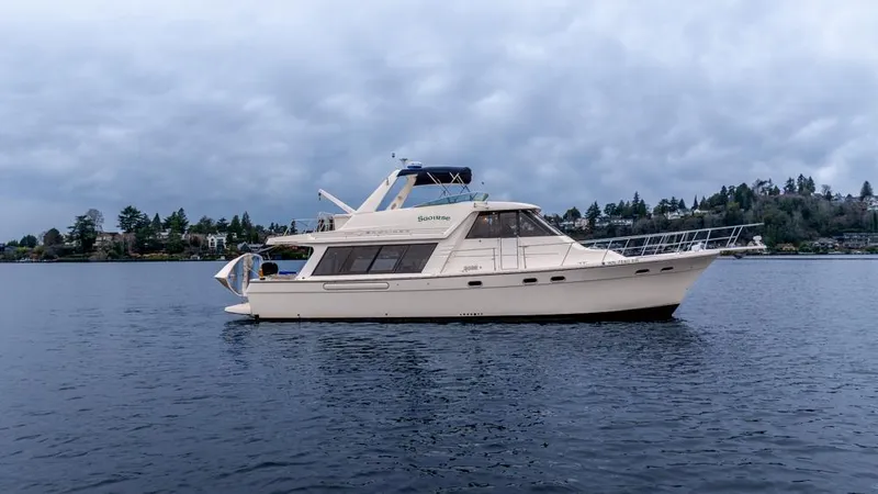 Slide: The Image of 2000 Bayliner 4788 Pilot House Motoryacht on calm water under cloudy sky. - 3