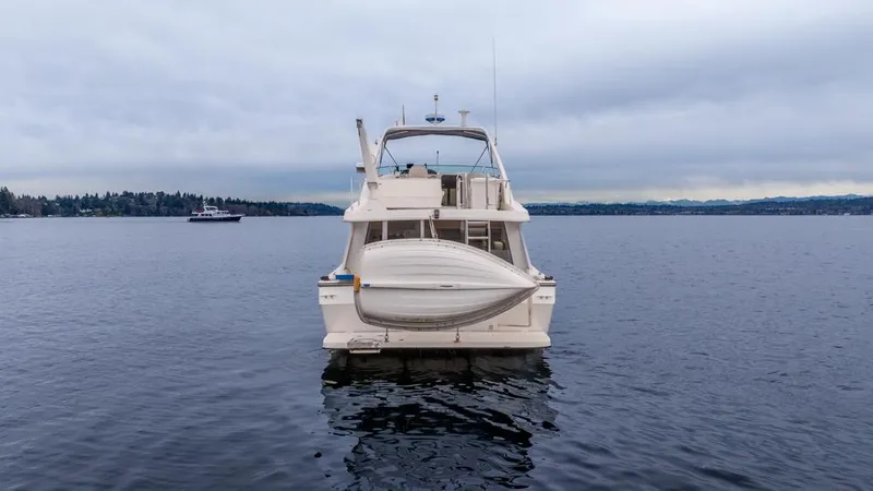 Slide: The Image of Bayliner 4788 Pilot House Motoryacht 2000 on calm water, rear view. - 4