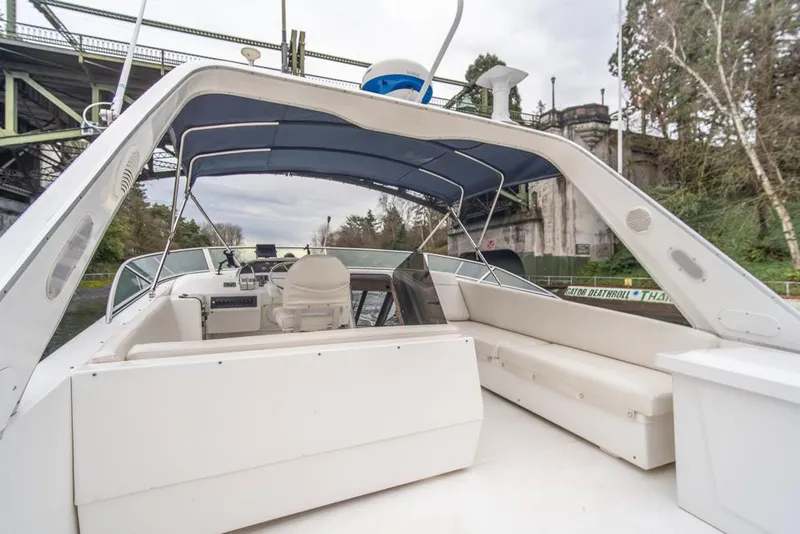 Slide: The Image of Bayliner 4788 Pilot House Motoryacht 2000, spacious deck with seating, under a blue canopy. - 47