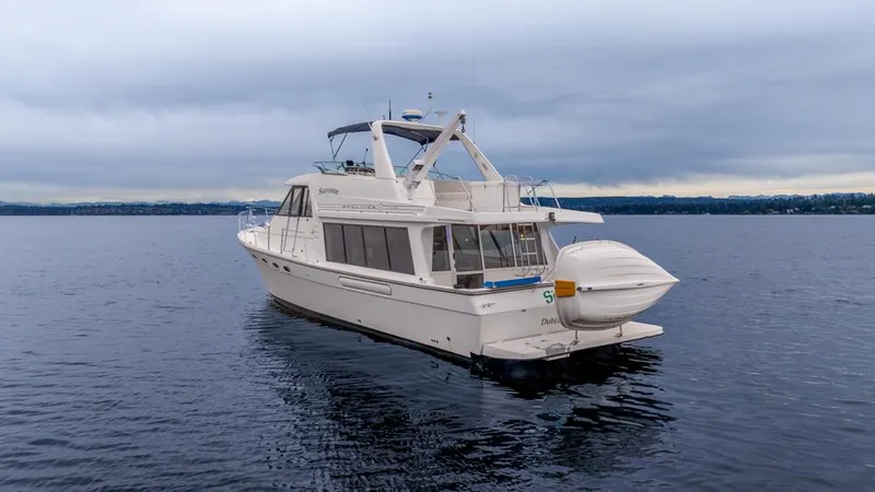 Slide: The Image of Bayliner 4788 Pilot House Motoryacht 2000 on calm water under cloudy sky. - 5