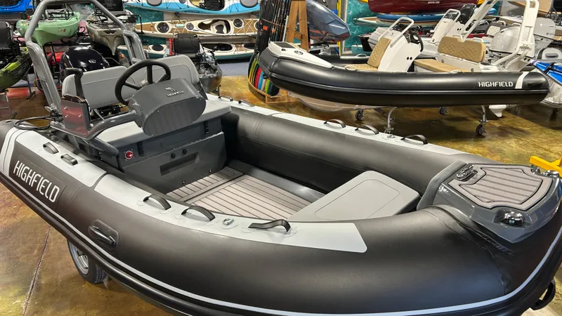 Slide: The Image of 2025 Highfield Classic 400 inflatable boat in showroom, featuring sleek design and modern seating. - 12