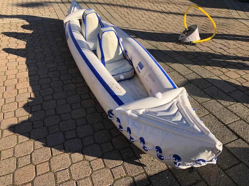 Slide: The Image of Inflatable kayak on paved surface with foot pump nearby. - 41