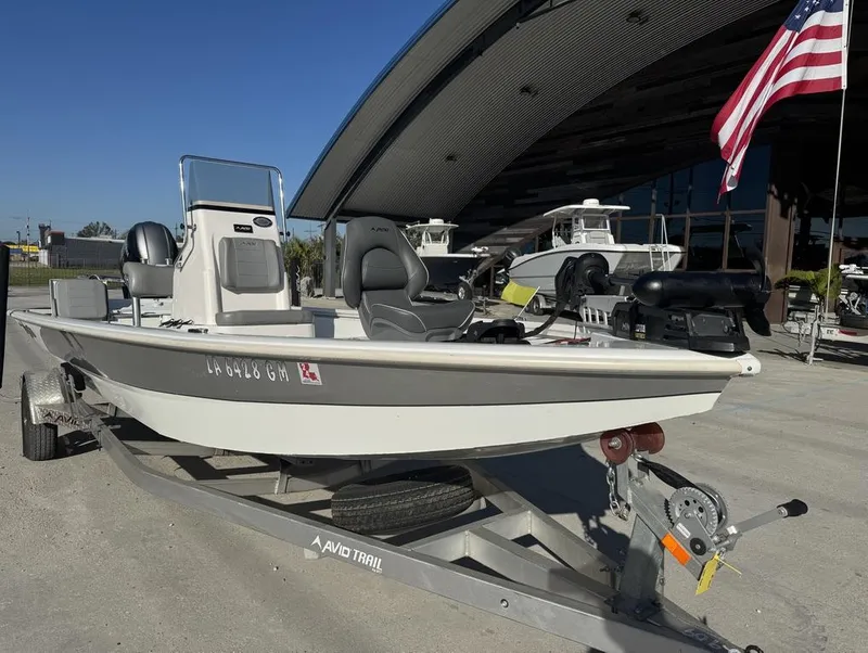 Slide: The Image of 2021 Avid FS boat on trailer, parked outdoors near a building and American flag. - 4