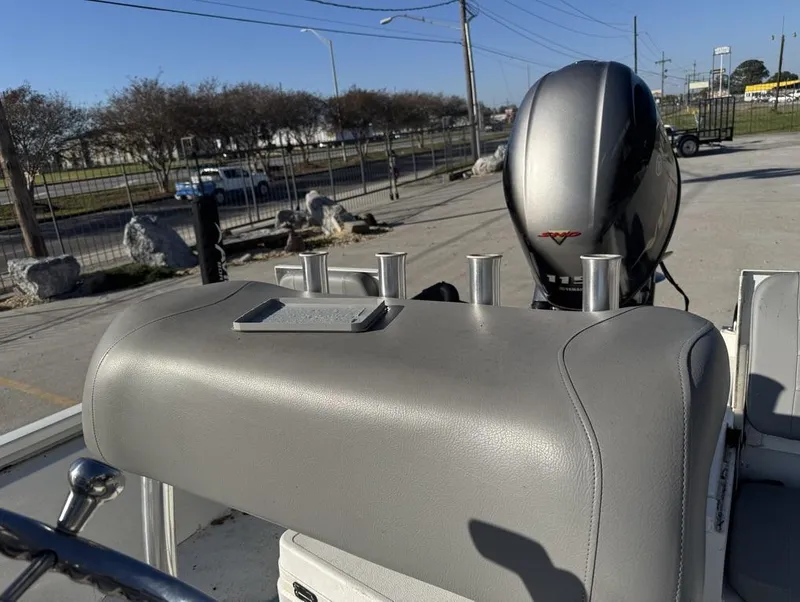 Slide: The Image of Avid FS 2021 boat with motor and rod holders in a parking area. - 8