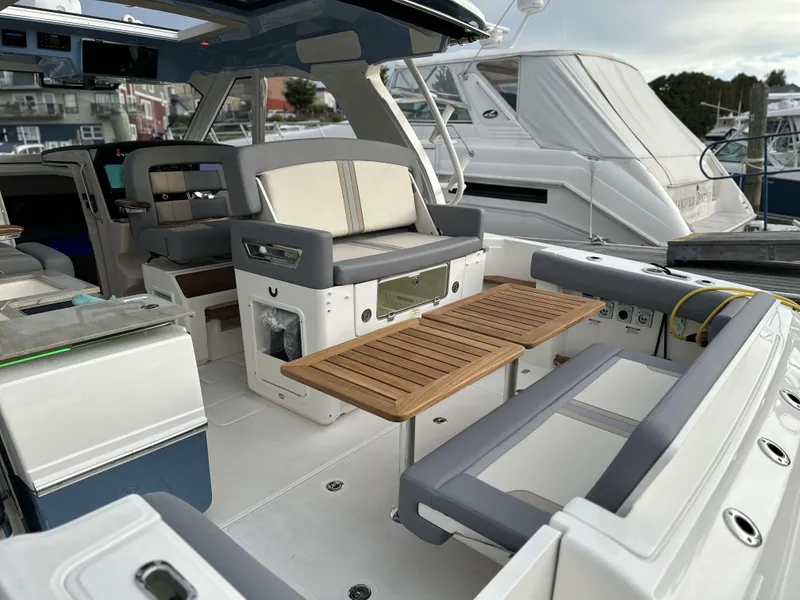 Slide: The Image of 2025 Boston Whaler 380 Realm boat interior with seating and wooden table. - 14