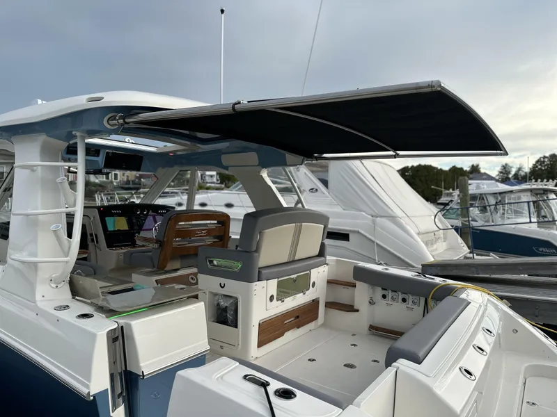 Slide: The Image of 2025 Boston Whaler 380 Realm boat with modern cockpit and seating at a marina. - 15